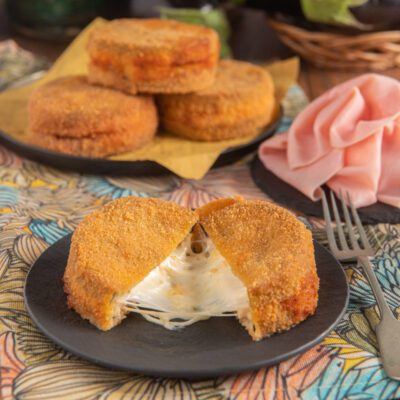 Cordon bleu di melanzane aperto a metà con filante mozzarella che fuoriesce dalla panatura dorata