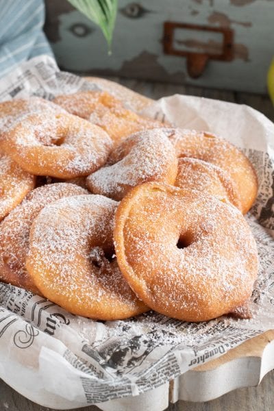 Frittelle di mele fritte e dorate, abbondantemente spolverizzate di zucchero a velo