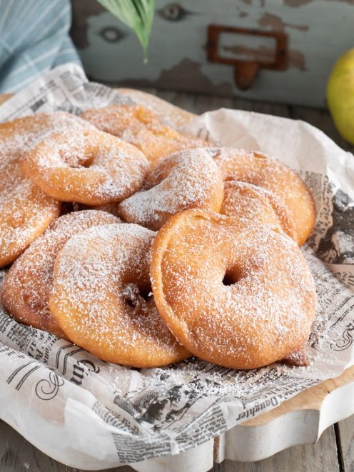 Frittelle di mele fritte e dorate, abbondantemente spolverizzate di zucchero a velo
