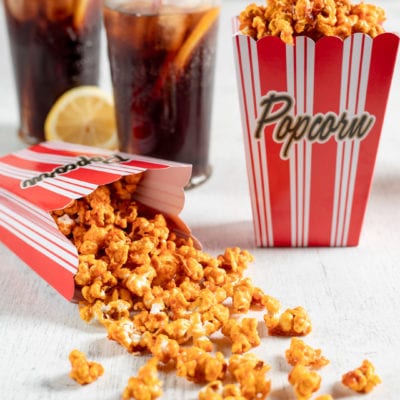 Popcorn al caramello salato che fuoriescono da un contenitore rovesciato