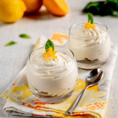 Spuma di ricotta agli agrumi in coppette di vetro con scorza grattugiata e foglia di menta