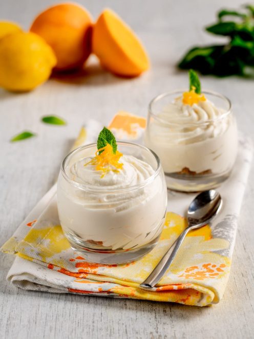 Spuma di ricotta agli agrumi in coppette di vetro con scorza grattugiata e foglia di menta