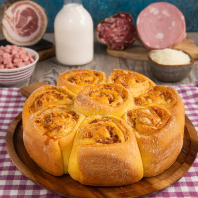 Torta salata di rose appena sfornata con ripieno di salumi e formaggio filante