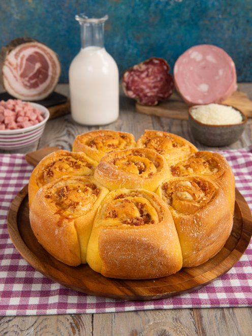 Torta salata di rose appena sfornata con ripieno di salumi e formaggio filante