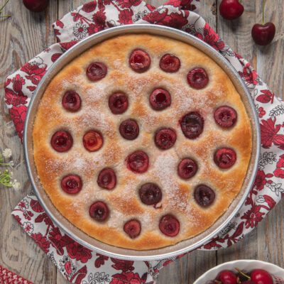 Focaccia alle ciliegie appena sfornata, con ciliegie intere affossate nell'impasto e zucchero in superficie