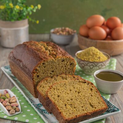 Plumcake al pistacchio affettato con mollica verde e pistacchi sgusciati accanto