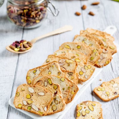 Tegole con mandorle e pistacchi disposte a ventaglio, croccanti e dorate con frutta secca in vista