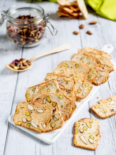 Tegole con mandorle e pistacchi disposte a ventaglio, croccanti e dorate con frutta secca in vista
