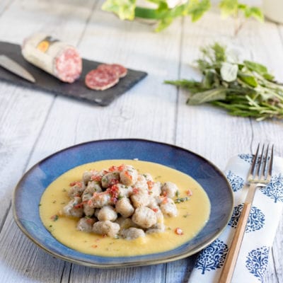 Gnocchetti alle erbe con briciole di salame adagiati su una crema di pane gialla e vellutata