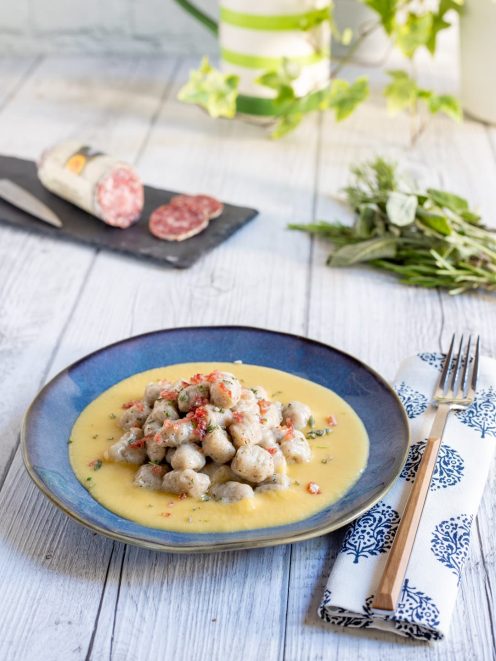 Gnocchetti alle erbe con briciole di salame adagiati su una crema di pane gialla e vellutata