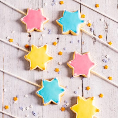 Bacchette magiche a forma di stella glassate in giallo, rosa e azzurro con perline decorative