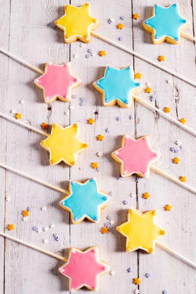 Bacchette magiche a forma di stella glassate in giallo, rosa e azzurro con perline decorative
