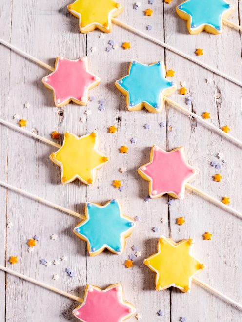 Bacchette magiche a forma di stella glassate in giallo, rosa e azzurro con perline decorative