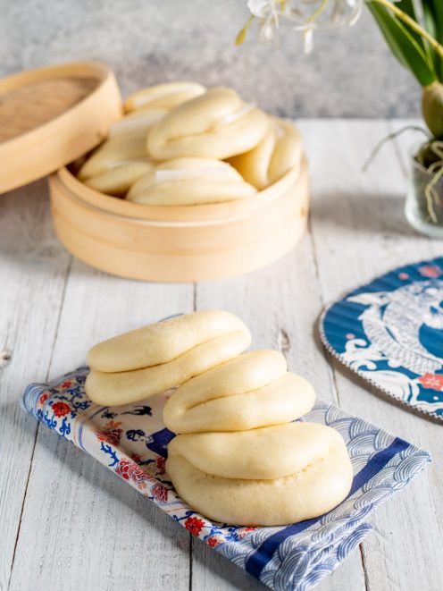 Bao buns al vapore appena sfornati, morbidi e gonfi, serviti in gruppo