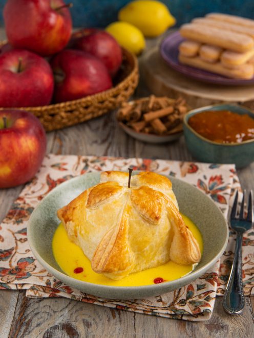 Mela in gabbia di pasta sfoglia dorata servita con crema inglese e gocce di coulis di lamponi