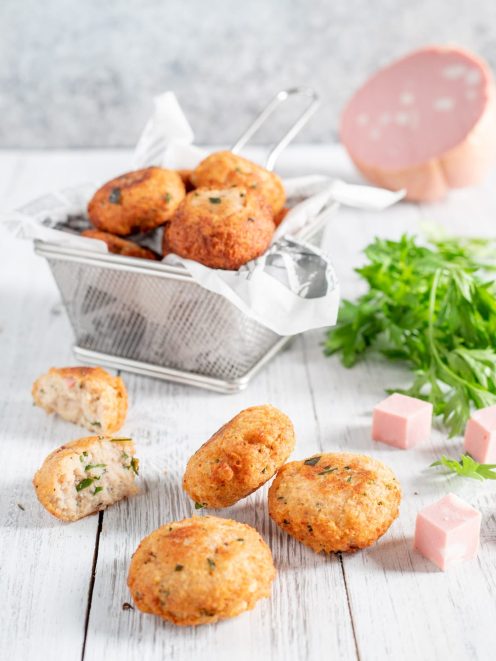 Polpettine di ricotta e mortadella fritte, una spezzata mostra il ripieno con prezzemolo