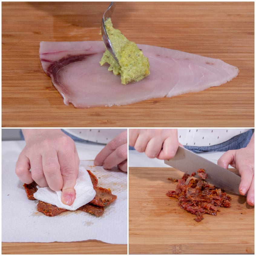 Fetta di pesce spada spalmata con pesto di pistacchi, pomodori secchi tamponati e tritati sul tagliere