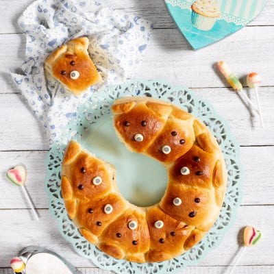 Corona di orsetti soffice a forma di ciambella, decorata con occhietti di zucchero e gocce di cioccolato