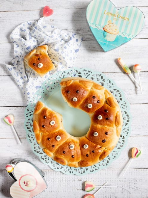 Corona di orsetti soffice a forma di ciambella, decorata con occhietti di zucchero e gocce di cioccolato