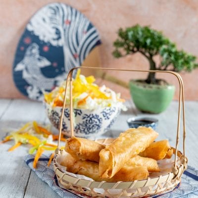 Popiah fritti croccanti serviti in un cestino di bambù con insalata di verdure julienne