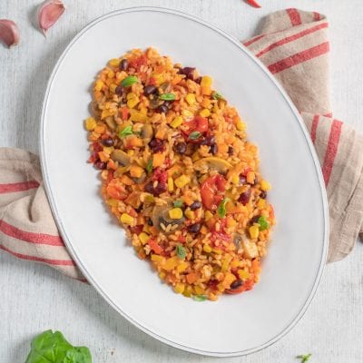 Riso saltato alla messicana con fagioli neri, mais, funghi, peperoni e foglie di basilico