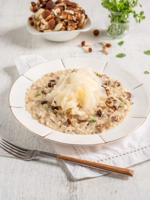 Risotto ai funghi con salsiccia, guarnito con scaglie di raspadura al centro