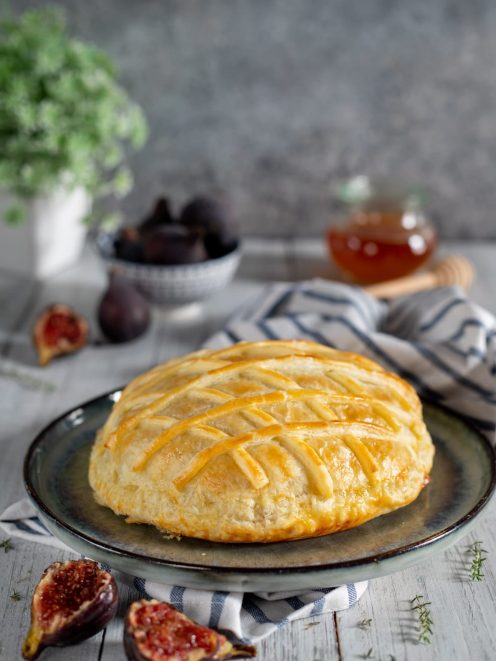 Scrigno di pasta sfoglia dorata con camembert e fichi freschi tagliati accanto