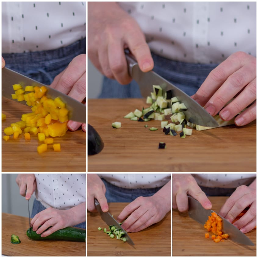 Verdure tagliate a cubetti piccoli sul tagliere: peperone giallo, melanzana, zucchina e carota