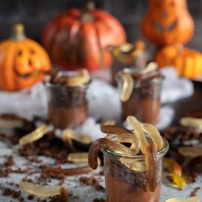 Lombrichi di Halloween nel vasetto con mousse al cioccolato, briciole di biscotto e caramelle gommose a forma di verme