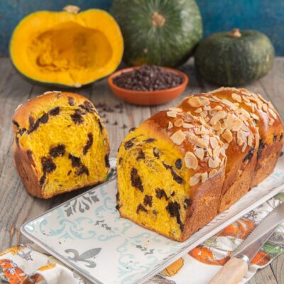 Pan brioche di zucca tagliato a fette, con mollica gialla e gocce di cioccolato, guarnito con mandorle a lamelle