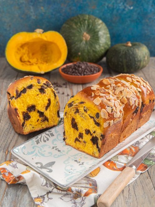 Pan brioche di zucca tagliato a fette, con mollica gialla e gocce di cioccolato, guarnito con mandorle a lamelle
