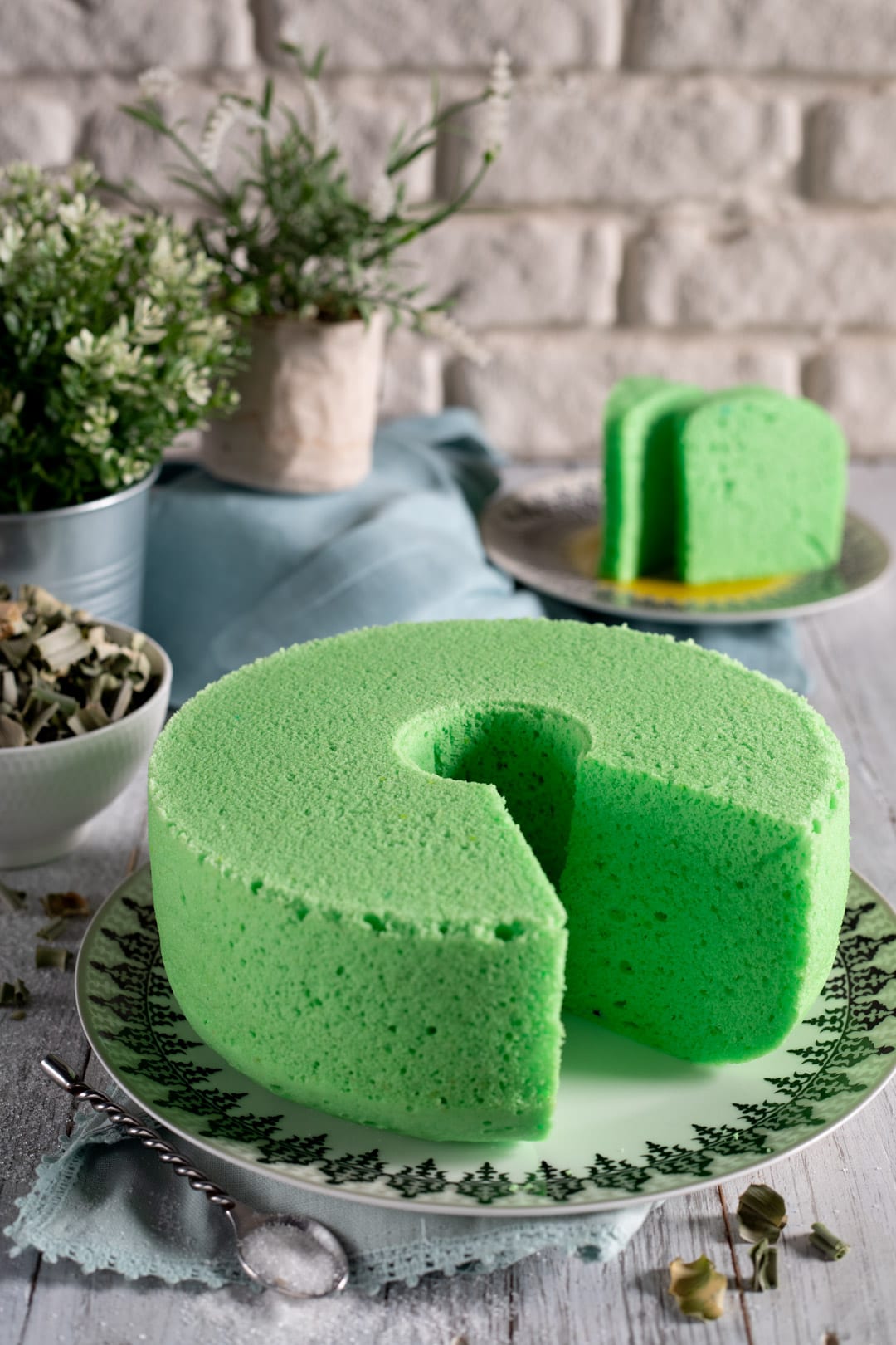 Pandan cake a ciambella con una fetta già tagliata che ne rivela la mollica soffice