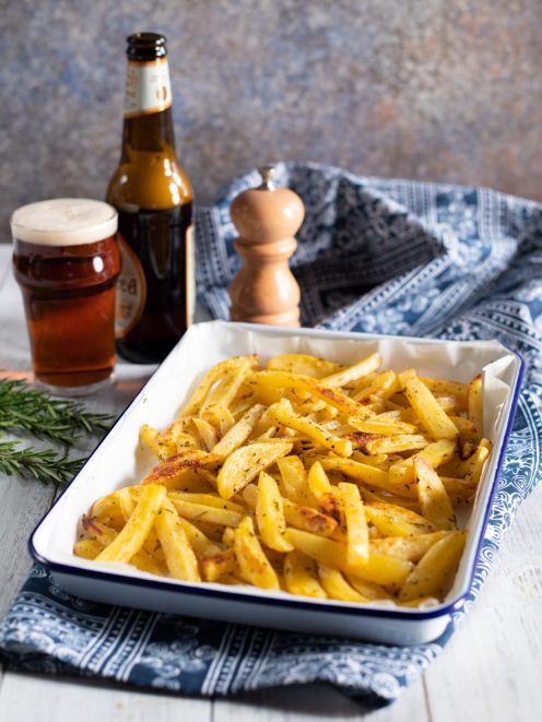 Patate alla birra al forno, dorate e aromatizzate con erbe, servite nella teglia