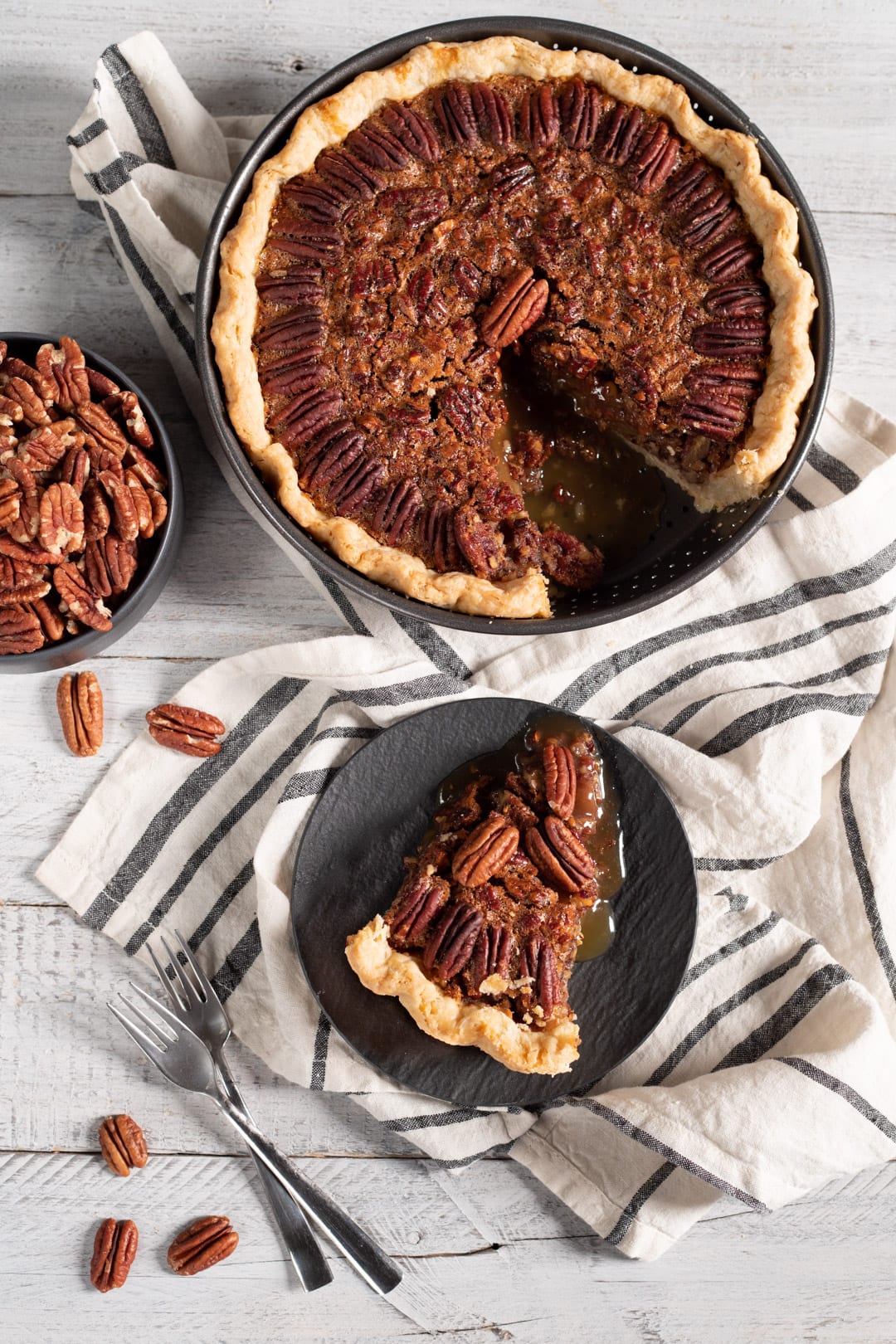 Fetta di pecan pie con ripieno caramellato e noci pecan intere servita su piatto