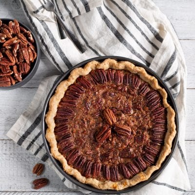 Pecan pie con ripieno caramellato e noci pecan disposte a cerchio sulla pasta frolla