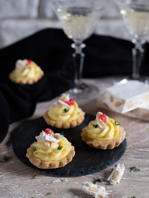 Tartellette con crema al parmigiano e torrone guarnite con ciliegine rosse e timo fresco
