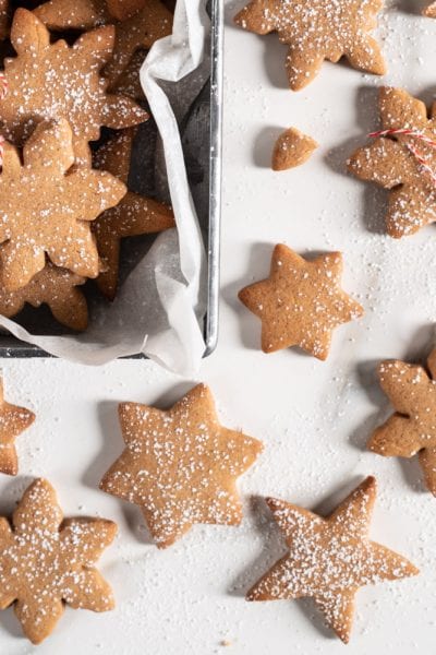 Biscotti svedesi pepparkakor a forma di stella e fiocco di neve spolverati di zucchero a velo