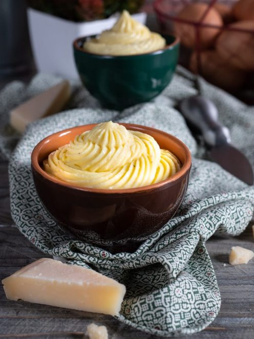 Crema pasticcera al Parmigiano servita a ciuffo con scaglie di formaggio accanto