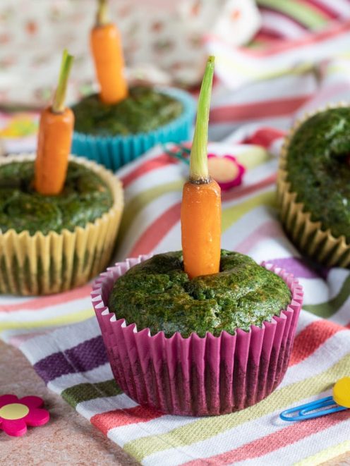 Cupcakes spinaci e carotine con una carota baby intera conficcata sulla sommità