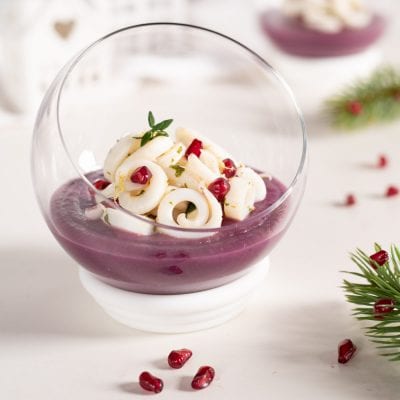 Tagliatelle di calamari su crema di patate viola con chicchi di melograno e foglioline di timo