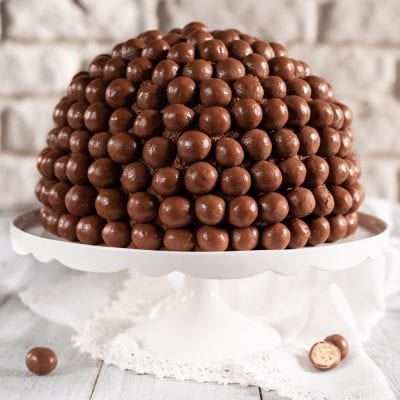 Torta Maltesers a cupola interamente ricoperta di palline di cioccolato al latte
