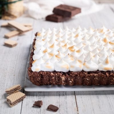 Torta meringata al cioccolato con base croccante e ciuffi di meringa tostati in superficie