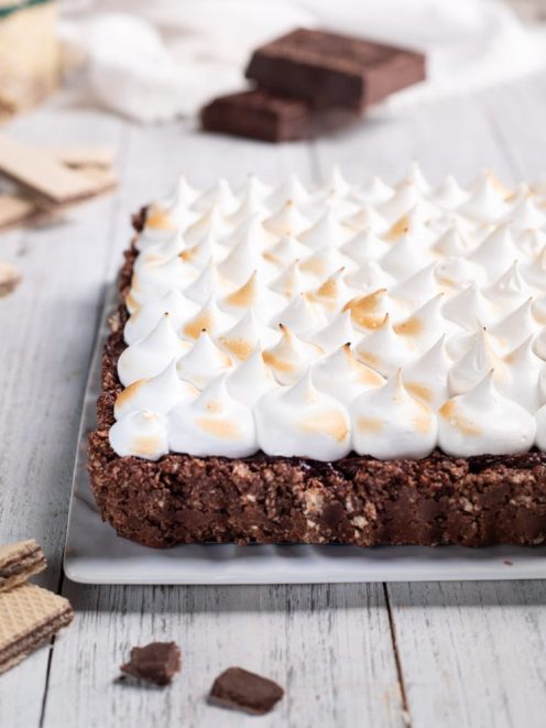 Torta meringata al cioccolato con base croccante e ciuffi di meringa tostati in superficie