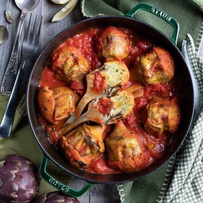 Carciofi ripieni al pomodoro cotti in padella con abbondante salsa di pomodoro