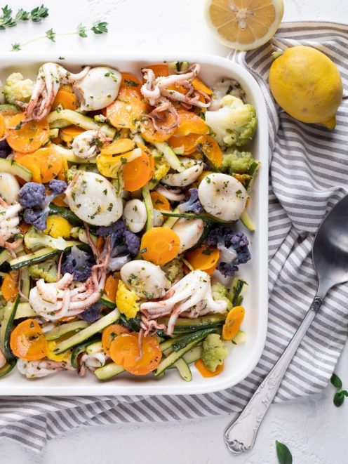 Moscardini con verdure al vapore: calamari, zucchine, carote, cavolfiore colorato e erbe aromatiche