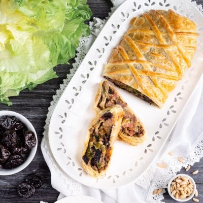 Strudel salato con scarola e prugne affettato, con il ripieno scuro e ricco ben visibile