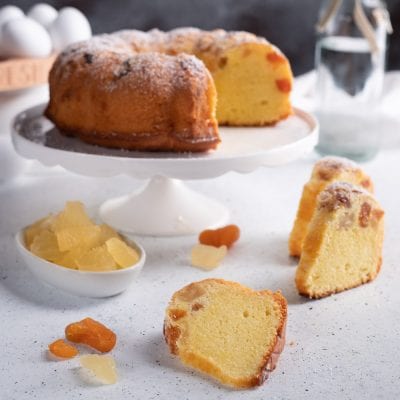 Torta Donizetti con frutta candita in fette, spolverata di zucchero a velo