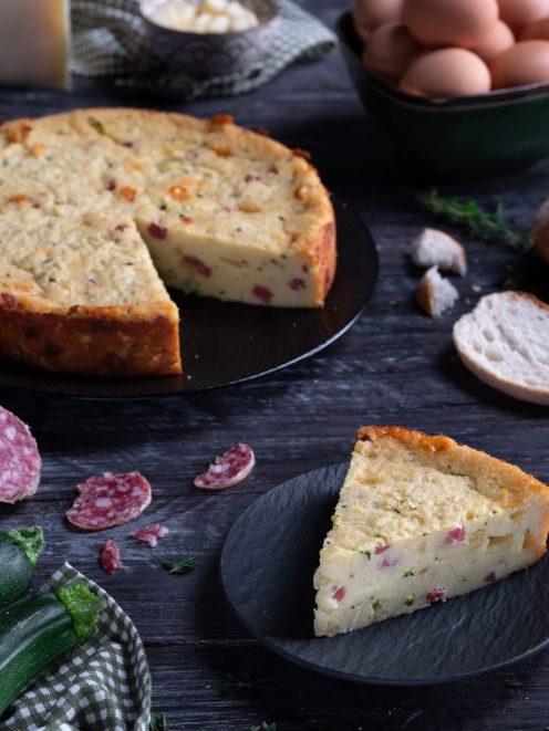 Torta salata di pane con una fetta tagliata che rivela il ripieno con salame e zucchine