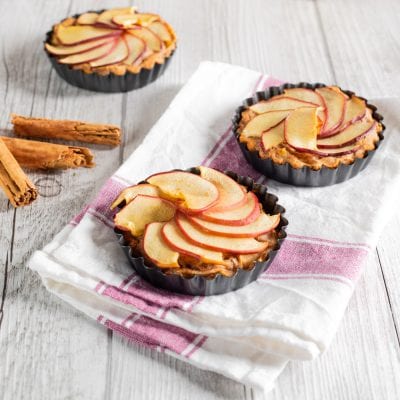 Tortine di mele e cannella con fettine disposte a ventaglio sulla frolla dorata
