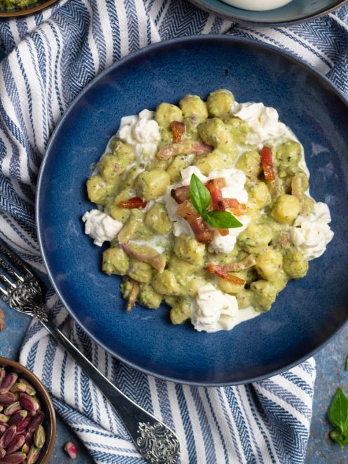 Gnocchetti con pesto di pistacchi, burrata e guanciale croccante, guarniti con foglie di basilico fresco